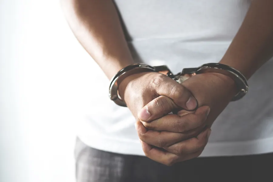 Mãos algemadas de uma pessoa em primeiro plano